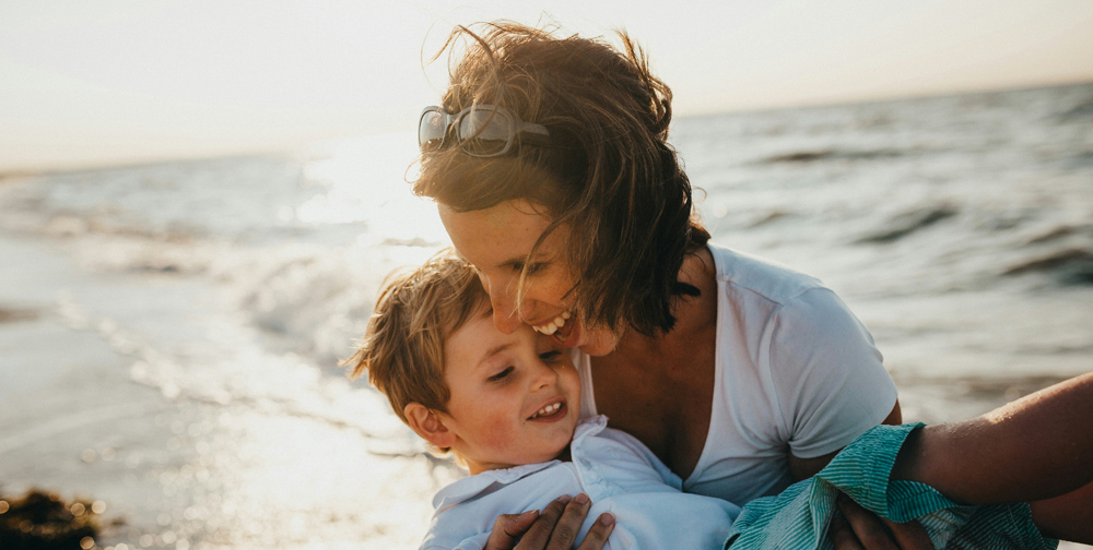 Madre disfrutando con su hijo en una playa