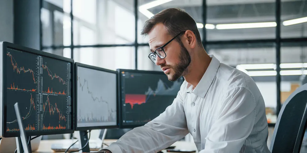 Evolución de los mercados financieros: primer trimestre 2024 broker revisando datos en la pantalla