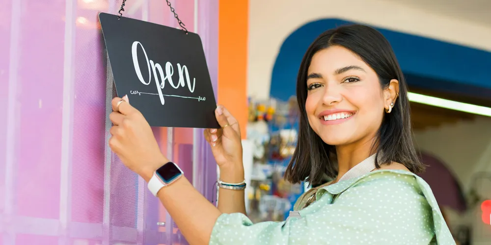 La regularización de la cuota de autónomos del 2023 mujer abriendo la puerta de su comercio