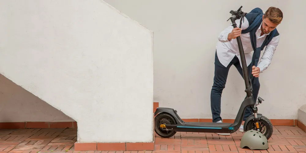 La nueva movilidad, un riesgo creciente Hombre preparando su patinete para empezar a andar