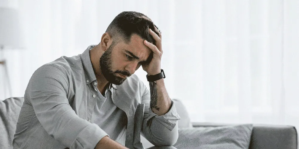 Hombre triste con la mano en la cabeza